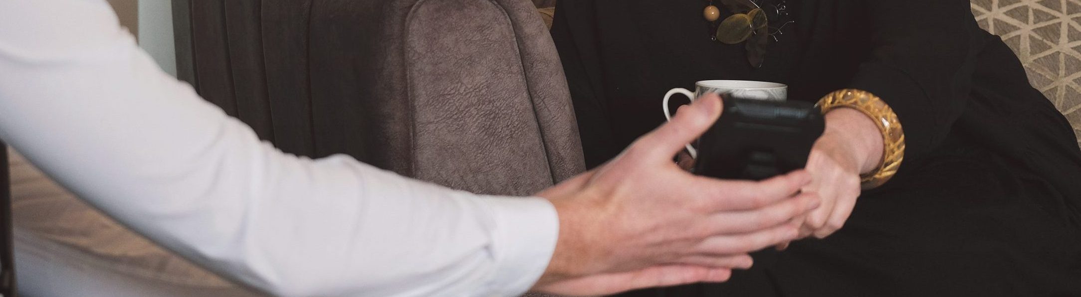 a young professional person providing guidance to another person, who is sat near them on a sofa